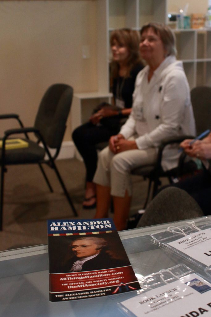 Photo by Keelin Everly-Lang / The Mirror
A flyer from the Alexander Hamilton Awareness Society. In the background, Faye M. shares that she purchased the book the week before and finished reading it right before the event.