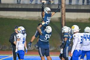 Jireh Ioane lifts up Nehemiah Washington after a touchdown. Photo by Dee Torres