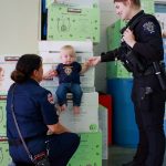 Photo by Keelin Everly-Lang / The Mirror
Captain Browning of South King Fire and Police Officer Britney Paul with Lieutenant Ann Hoags son celebrate the diapers purchased through community donations.