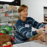 Volunteer Denise Ward hands a frozen chicken to a guest at the Multi-Service Center food bank. Photo by Keelin Everly-Lang / The Mirror.