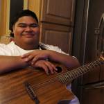 Decatur High School senior and American Idol contestant Iam Tongi sits at home on March 1. His father Rodney spent a bonus from his job as an electrician to buy Iams guitar. Tongi went on to win this years season of American Idol. (Photo by Alex Bruell / The Mirror)