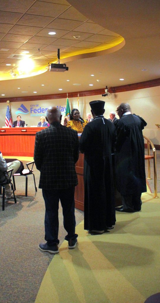 Councilmember Lydia Assefa-Dawson takes her oath from King County Superior Court Judge LeRoy McCullough with community leaders Pastor Berhanu Feleke and Father Abiye Belay. (Photo by Keelin Everly-Lang / The Mirror)
