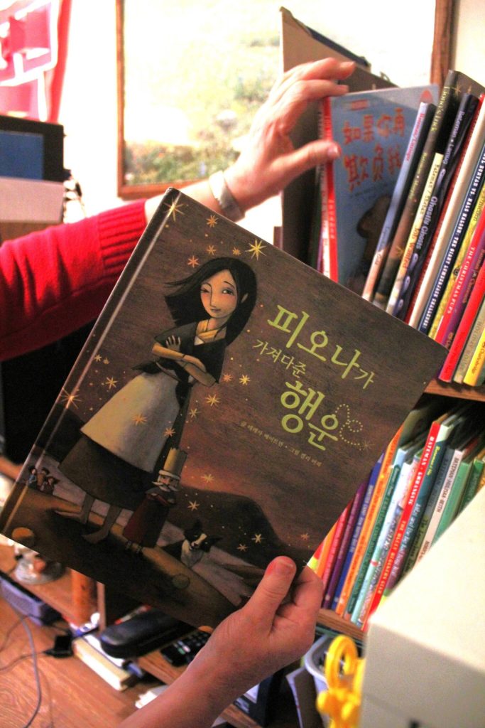 Teresa Batemans books have been translated into several languages by her publisher, including this copy of Fionas Luck that has been translated into Korean. Behind the book are two shelves of books she has published that make up one side of her writing desk. Photo by Keelin Everly-Lang for the Mirror.