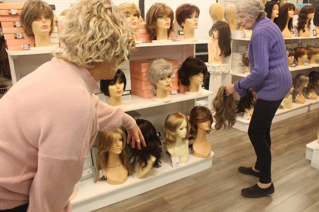 Photo by Bailey Jo Josie/Sound Publishing
Staffers at Master Hair Care try and find the best wig.