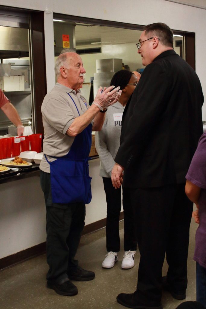 Tony Robinson of Knights of Columbus talks with Bishop Schuster at the annual fish fry. Photo by Keelin Everly-Lang / The Mirror