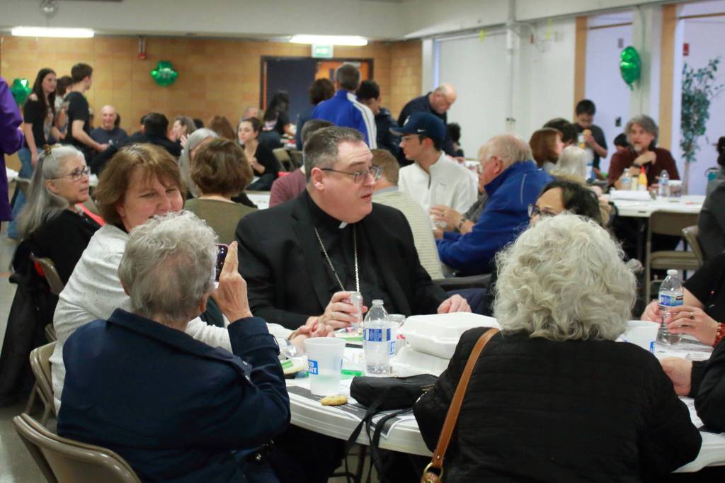 Bishop Schuster stopped by the annual fish fry on March 22 and caught up with community members. Several of the individuals at that table have attended St. Vincent de Paul for half a century. Photos by Keelin Everly-Lang / The Mirror