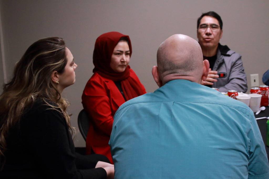 In addition to religious differences, some language barriers added another layer of challenges at the Iftar event hosted by the Al-Maidah initiative. Guests at this table found a creative way around it by taking turns speaking into translation apps to get to know each other better. Photo by Keelin Everly-Lang / The Mirror