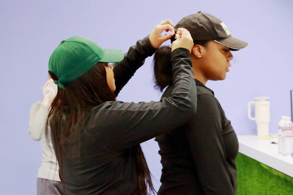 Jaden Bullard fixes Rohna Grant-Giles hat during a break at the Tuesday night class at the Trap Lab. The boutique fitness studio was created to be a place of support and sisterhood, according to founders Icea Pettigrew and Sharde Bullard.