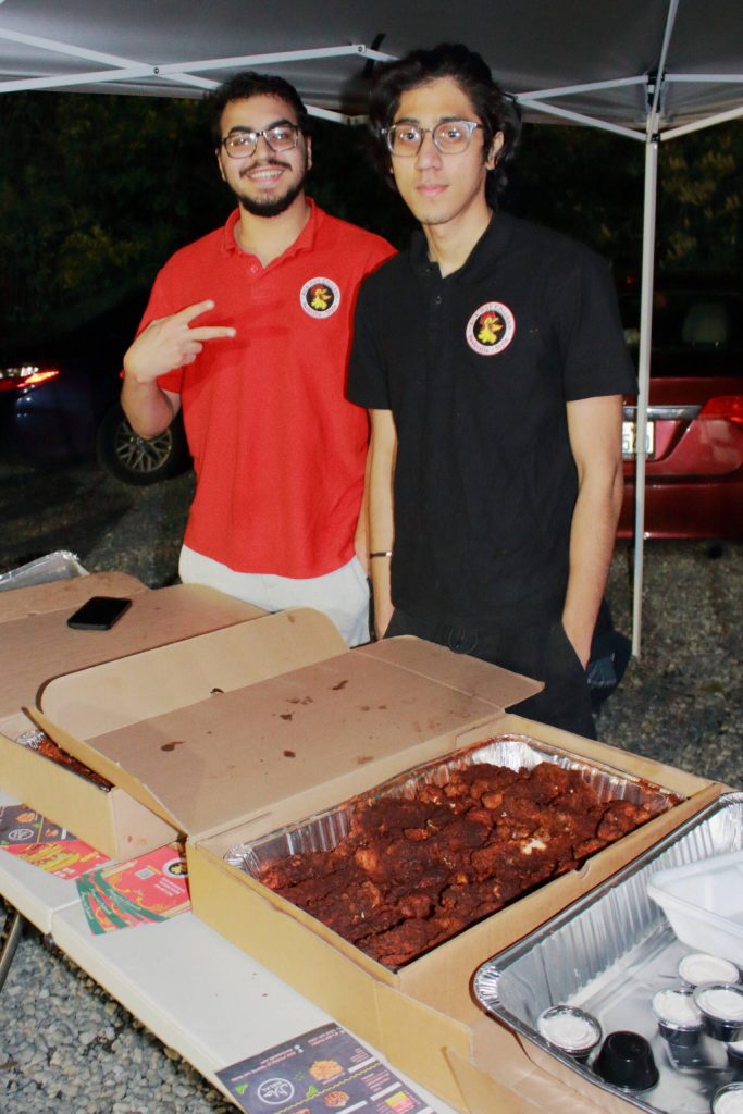Emad Vassa and Sameer Lohawala serve meals from Als Hot Chicken in Federal Way at the Chand Raat Mela on April 9.