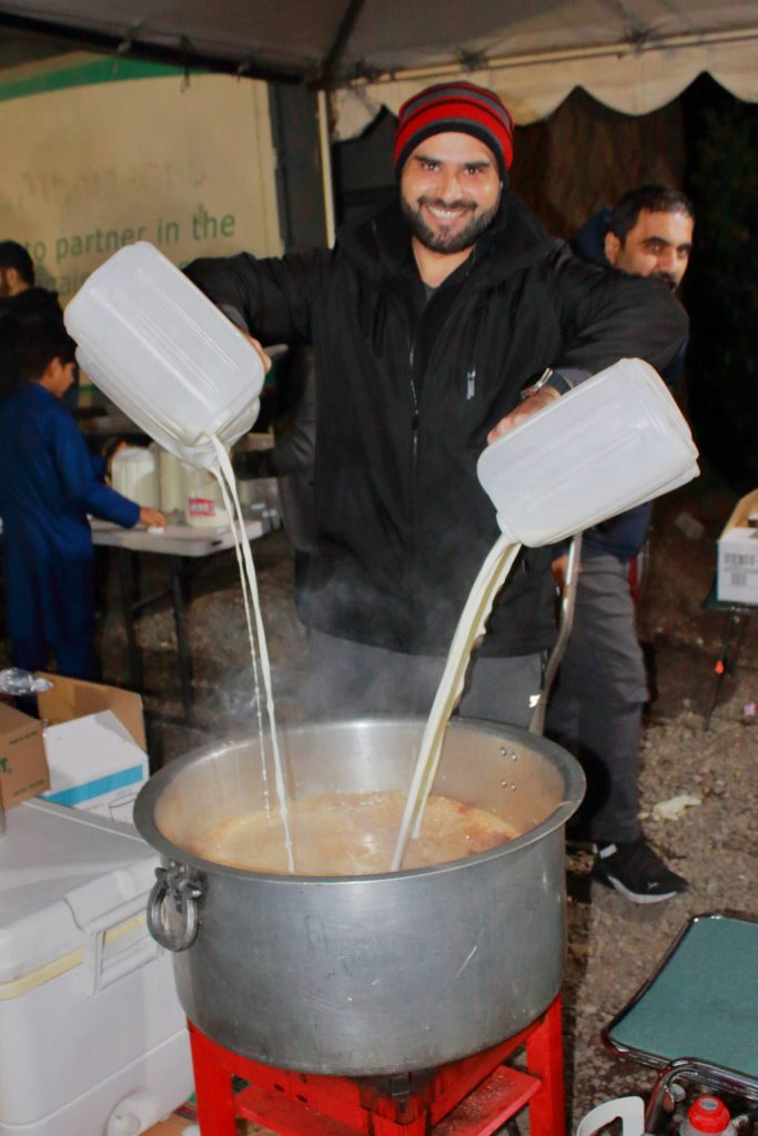 Ikram Haq pours milk into a large pot of chai that kept guests warm and energized. The tea operation is run by Mohammed Ihsan who has been making tea for the community the whole month of Ramadan for nightly iftars.