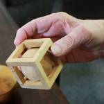 Artist Dick Ode said he has enjoyed working with wood since he was a young, and used it as a way to pass the time while traveling for work. This wooden ball and cube were whittled at the same time from the same solid block. Photo by Keelin Everly-Lang / The Mirror