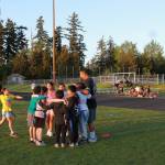 Coach Mona calls for a team huddle after practice with the U-8 players. He grew up playing rugby in New Zealand and found community when moving to this area through the sport. Photo by Keelin Everly-Lang / The Mirror
