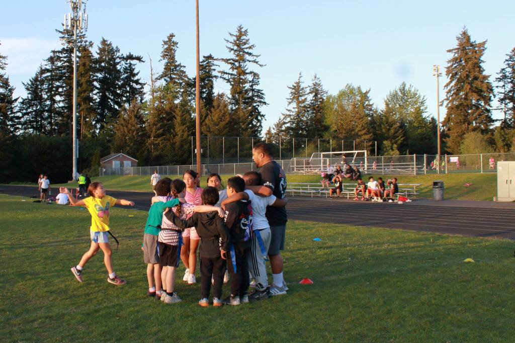 Coach Mona calls for a team huddle after practice with the U-8 players. He grew up playing rugby in New Zealand and found community when moving to this area through the sport. Photo by Keelin Everly-Lang / The Mirror