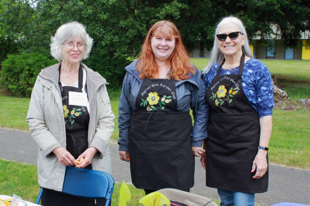 Judy McDonald, Carrie Asselin and Mary Beth Lanza are part of the Marine Hills Garden Club which consistently supports school gardens in FWPS in a variety of ways. At the Twin Lakes Elementary community garden opening, they taught attendees how to create seed bombs using newspaper scraps. Photo by Keelin Everly-Lang / The Mirror