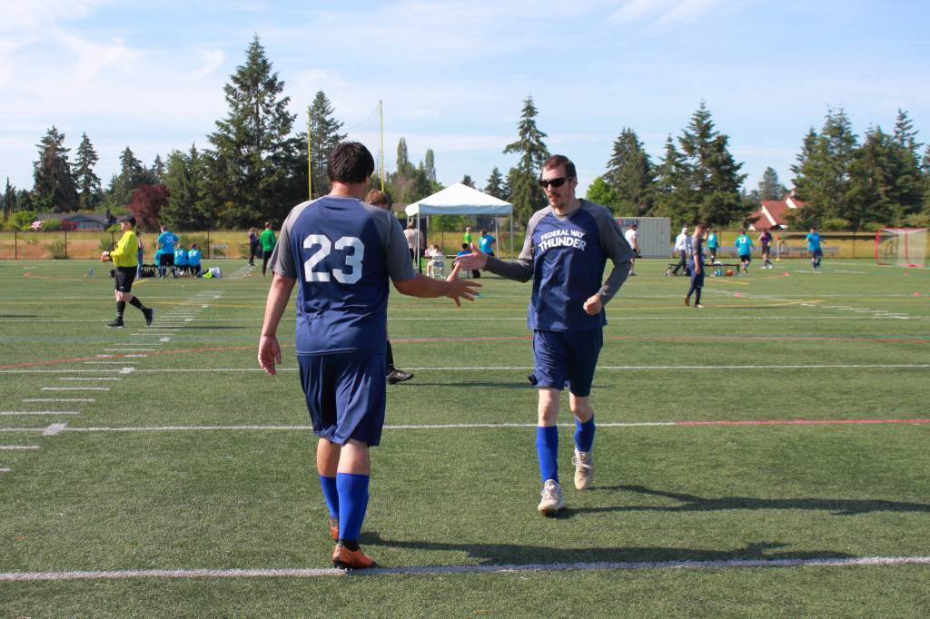 John Emmett and Troy Robert Marsh swap out during their first game at the Special Olympics where the team ultimately took silver.