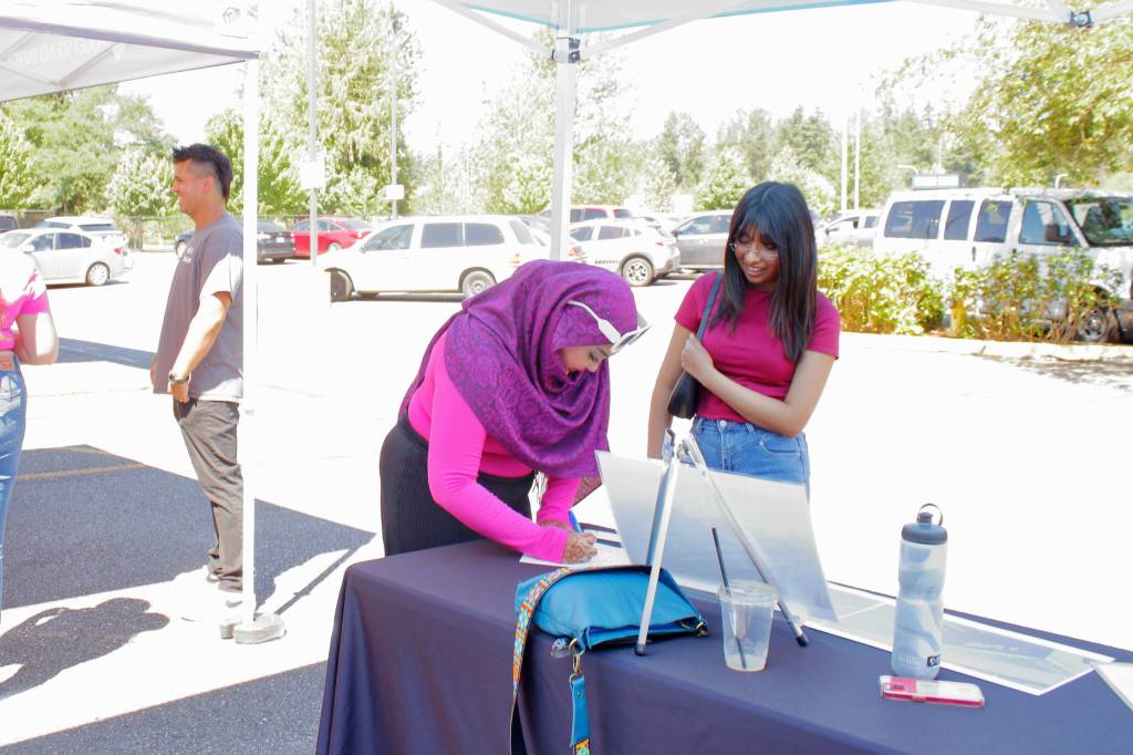 Guests fill out interest forms for a 200 hour training program for work in the solar industry through Sphere Solar Energy. Photo by Keelin Everly-Lang / the Mirror