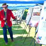 Guests not only dressed up in their tea party best - some emulated the Mad Hatter to get into the fun, like this guest who is showing off the prize packages for the auction. Photo by Bruce Honda.