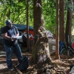 Homelessness Outreach Program Coordinator Kent Hay delivering mail to a resident of the camp on Aug. 27, 2021. Sound Publishing file photo