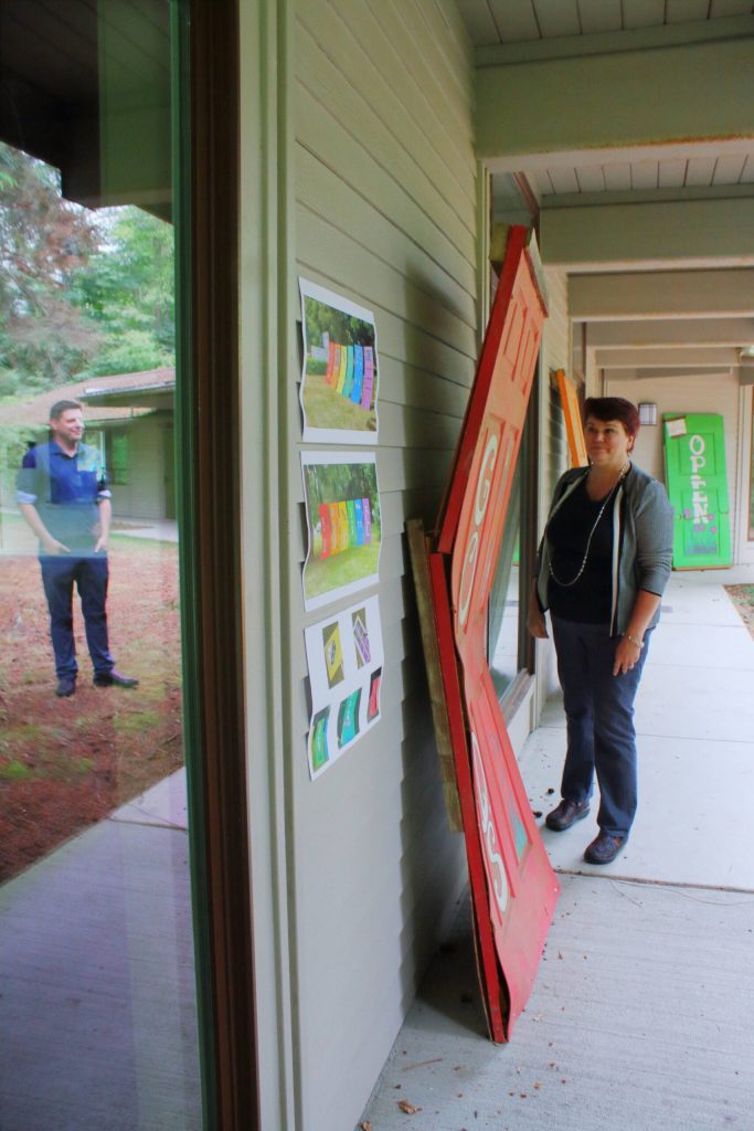 Christopher Landers-Agosto are two volunteers who have been involved in creating the closet. Here they stand by an earlier version of the churchs pride doors that was vandalized in the past. Next to the old doors is an informational poster about the history of the doors, their vandalization, and how theyve continued to put up new ones.