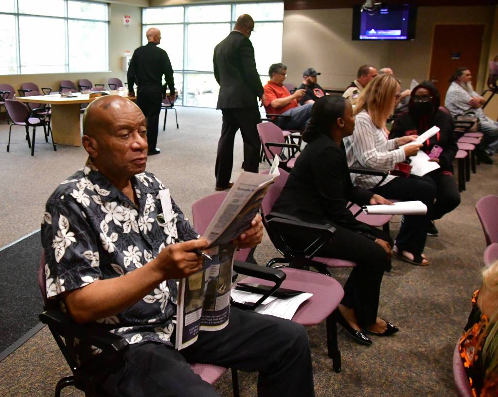 A community member reads the Mirror while waiting for the City Council meeting to begin. Photo by Bruce Honda.