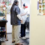 Lamont Styles gives barber student Samual Walker Bino some pro tips while he works on a customers haircut. He is almost done with the barber program and will soon test for his license. Photo by Keelin Everly-Lang / the Mirror.