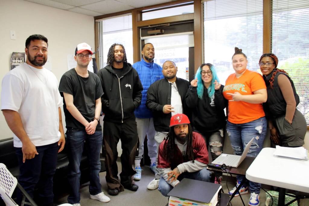 Students pose with a guest speaker at Lifes Styles who shared professional tips and answered their questions about a barbering career. From left to right: Daren Lefeau, Samuel Walker, Tae Gatson, James Tyler III, MJ Burgos, Daniel Dickson Jr., Betzy Martinez, Sam Folk and Keyaura KM-WR. Photo by Keelin Everly-Lang / the Mirror