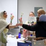 Interpreter Sheelan Shamdeen shared the bouquet she received for her work interpreting with the rest of the graduates, saying you are all flowers, you deserve flowers! Photo by Keelin Everly-Lang / the Mirror
