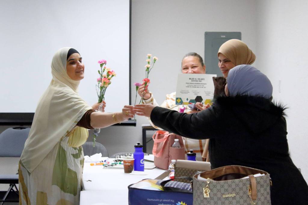 Interpreter Sheelan Shamdeen shared the bouquet she received for her work interpreting with the rest of the graduates, saying you are all flowers, you deserve flowers! Photo by Keelin Everly-Lang / the Mirror