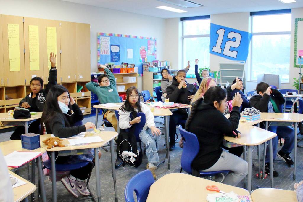 Students raise their hands to indicate that they participated in breakfast that morning during attendance. Each class tracks meals a different way, finding how best to seamlessly integrate it into their usual morning activities. Photo by Keelin Everly-Lang / the Mirror.