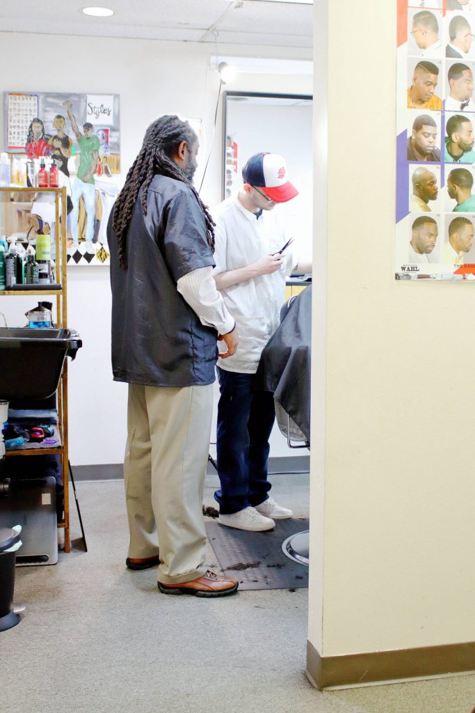Lamont Styles gives barber student Samual Walker Bino some pro tips while he works on a customers haircut. He is almost done with the barber program and will soon test for his license. Photo by Keelin Everly-Lang / the Mirror.
Lamont Styles gives barber student Samual Walker Bino some pro tips while he works on a customers haircut. He is almost done with the barber program and will soon test for his license. Photo by Keelin Everly-Lang / the Mirror.
