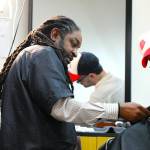 Lamont Styles guides a barber student in finishing up a free haircut for a customer. Lifes Styles offers free haircuts to give back to the community and help students get in plenty of practice. Photo by Keelin Everly-Lang / the Mirror.