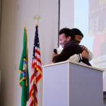 Medichael Mereste is now a college student and emceed the Communities in Schools event on March 7. Here, he and mentor and founder of Black Equality Coalition Anthony Curtis embrace as Curtis takes the stage. Photo by Keelin Everly-Lang / the Mirror