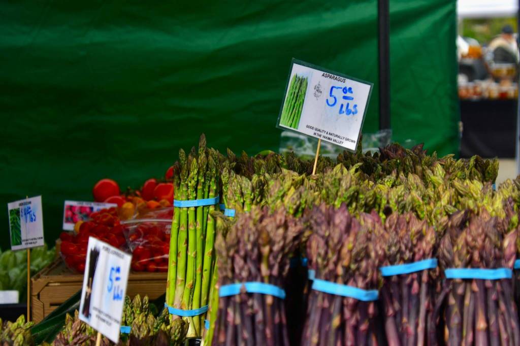 Seasonal spring produce was on display at the Federal Way Farmers Market on opening day May 10, like unique purple asparagus from local farms. Photo by Bruce Honda