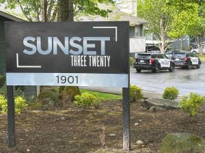 The Sunset Three Twenty Apartments, with three police SUVs in the background responding to a call on a different night than the homicide. Photo by Joshua Solorzano/The Mirror.