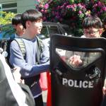 Students from Hachinohe, Japan, get an introduction to Federal Way and the United States by meeting police officers and holding riot shields. Photo by Keelin Everly-Lang / the Mirror