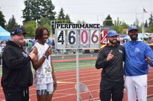 Geron White, coaches and dad Geno (far right) stand next to his meet winning triple jump. Ben Ray / The Mirror