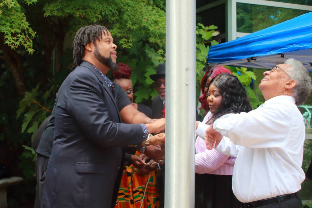 Pastor Joseph Bowman opened up the event with a prayer then was one of several community members to help raise the flag celebrating Juneteenth. Photo by Keelin Everly-Lang / the Mirror