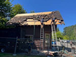 Horizon Roofing staff work on the Denny Cabin roof replacement outside West Hylebos Wetlands Park, 411 S. 348th St. Photo credit: Rob Rostad, provided by the Historical Society of Federal Way
