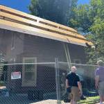 Historical society members admire the progress of the Denny Cabin roof replacement, including the plank decking underneath the tar paper and cedar shingles that is in good enough condition to not need to be replaced. The cabin is located at West Hylebos Wetlands Park, 411 S. 348th St. Photo credit: Rob Rostad, provided by the Historical Society of Federal Way