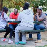 Fathers Dias Mobula and Bekmay Kayembe in a conversation with the next generation after the days environmental work has been completed. Photo by Keelin Everly-Lang / The Mirror