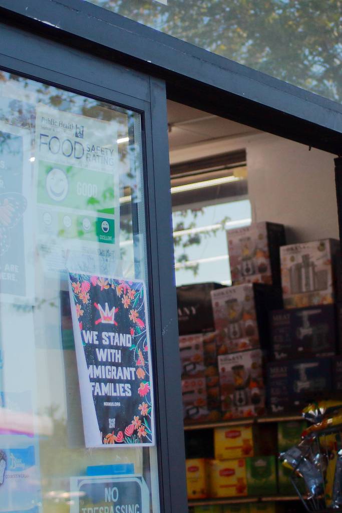 A friendly message on the door of a local grocer states we stand with immigrant families. Photo by Keelin Everly-Lang / the Mirror