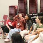 Colla Voce students cringe as their director shows them how to do the brat rot warm-up at the beginning of rehearsal. Photo by Bailey Jo Josie/Sound Publishing.