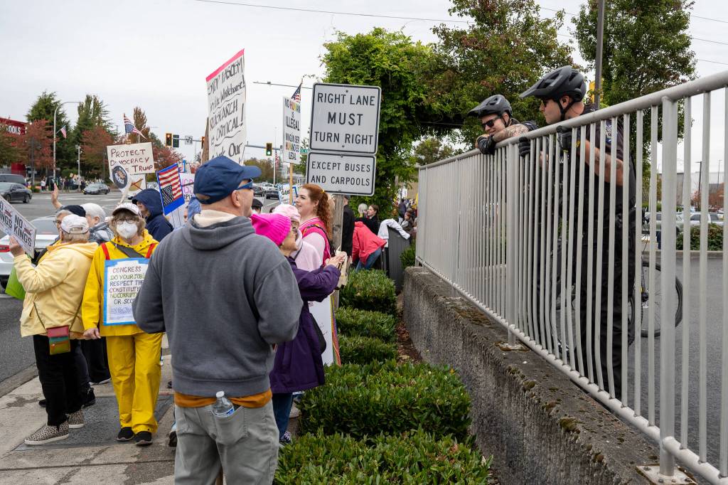 Demonstrators speak to Federal Way Police Department officers at the No Kings protest on Oct. 18 in Federal Way. The FWPD confirmed that there were no issues or violence at the event. Photo by Rachel Jones