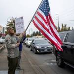American flags and expressions of love for the country were everywhere at the No Kings protest, like this individual wearing a U.S. Army shirt and holding an American flag. The protest took place on S. 320th Street, which has the honorary name Veterans Way. Behind him is someone holding a sign stating Remember your pledge? With liberty and justice for ALL. Many signs included messages of opposition to the current administration and overreaches of constitutional authority. Photo by Rachel Jones
