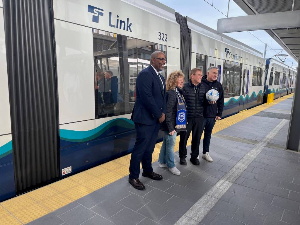 Standing for a photo op next to the moving light rail train in Federal Way, pictured left to right: King County Councilmember DeSean Quinn, Auburn Mayor Nancy Backus, King County Councilmember Pete von Reichbauer and Sound Transit CEO Dow Constantine. Staff photo