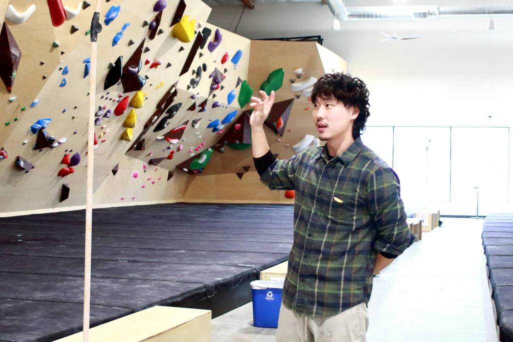 Founder Seung Park describes the details that make Climb NORA stand out, like high quality grips, employing two full-time setters to build new routes every six weeks, and even the dimensions of the space, including leaving space between the climbing walls and the ceiling. Photo by Keelin Everly-Lang / the Mirror