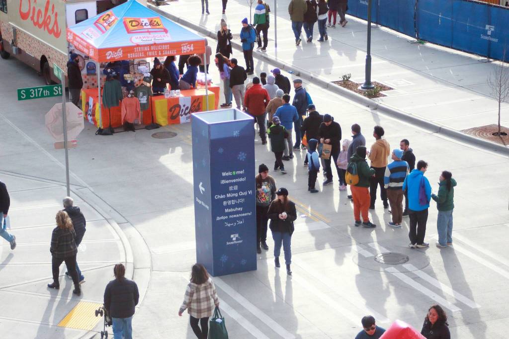The line for burgers and prizes from Dicks was consistent throughout the day during the Federal Way festivities for opening day for the new light rail station. Photo by Keelin Everly-Lang /the Mirror