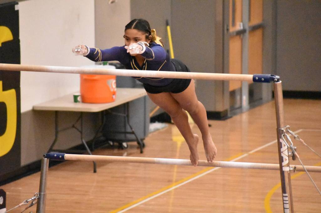 Amyah Johnson reaches for the bar in her uneven bar routine. Ben Ray / The Mirror