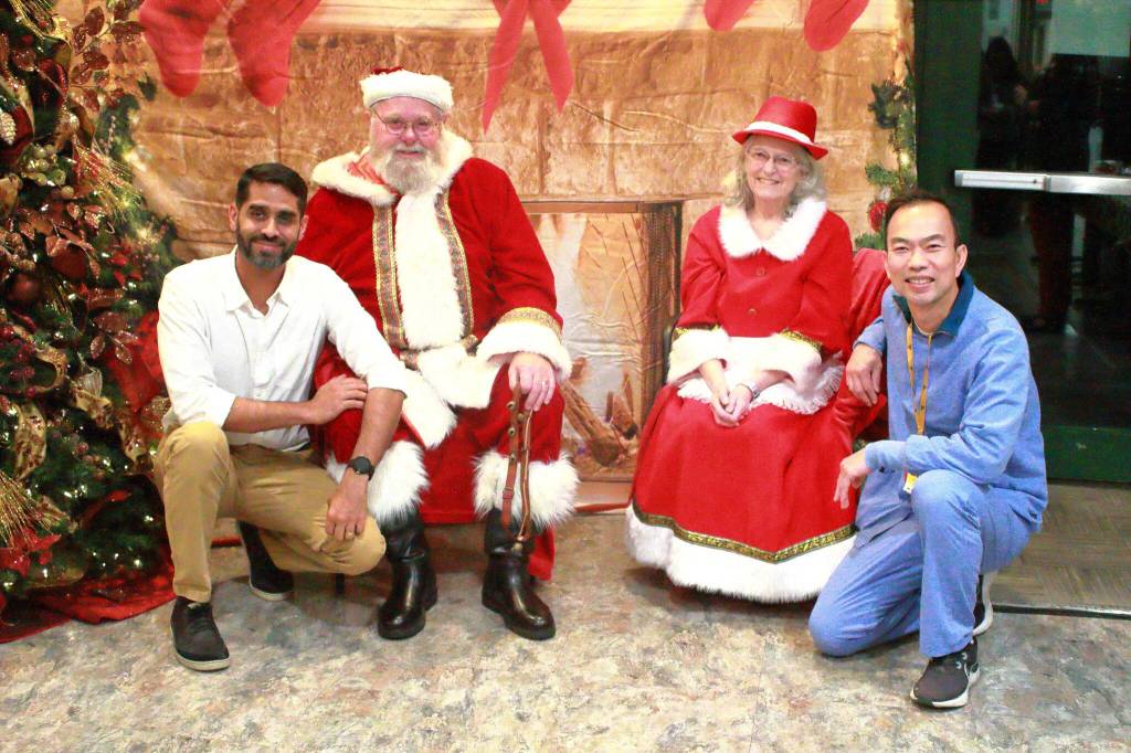 Hospitalists Tuscano Thomson and Andy Nguyen take a break from their work to pose with Santa and Mrs. Claus at St. Francis Hospital in Federal Way. Photo by Keelin Everly-Lang / the Mirror.