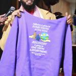 Hussein Ugas holds up a sweatshirt from Rahma Recovery that says: "Addiction is giving up everything for one thing. Recovery is giving up one thing for everything." Photo by Keelin Everly-Lang / the Mirror